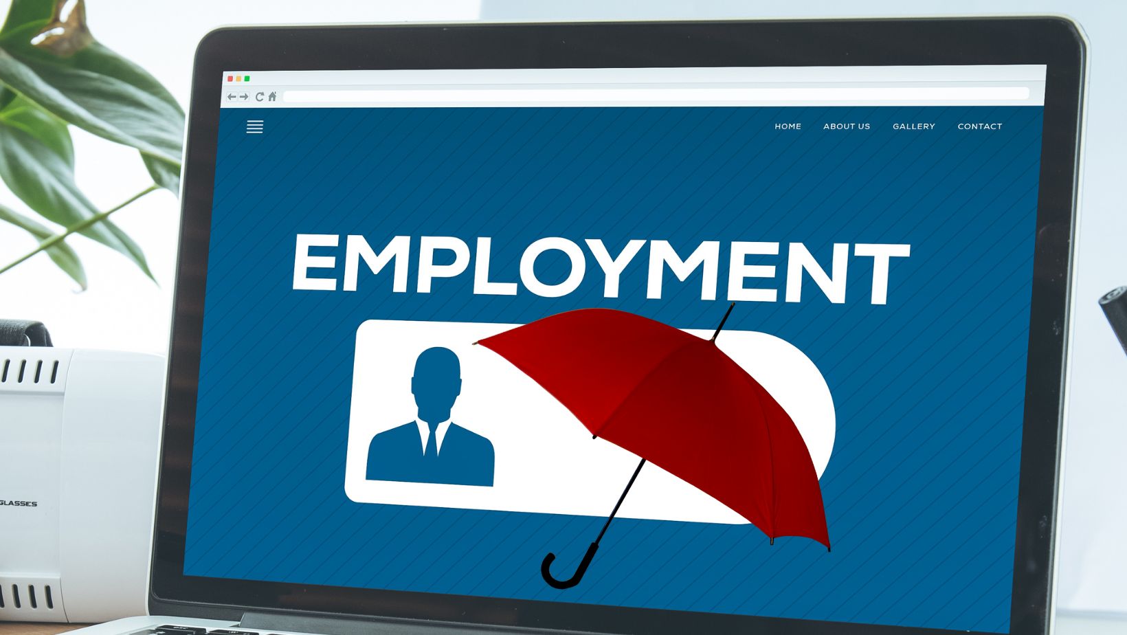 a laptop with the word employment on the screen and a red umbrella hovering over the silhouette of a man